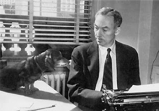 E. B. White at work, with his Dachsund looking on.