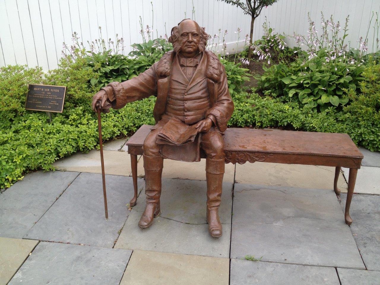 At Broad and Hudson Streets in Kinderhook, New York, one can sit with a statue of Martin Van Buren, and see if one can decipher the newspaper he is reading. PresidentsUSA image