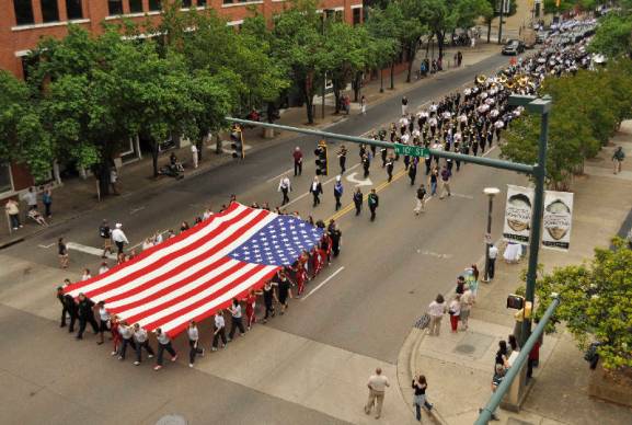 Caption from the Chattannoga Times-Free Press: Students from Soddy-Daisy High School participate in the annual Armed Forces Day Parade by marching while holding a large American flag today on Market Street in downtown Chattanooga. Participants marched the length of Market Street as they were cheered on by crowds gathered on the sidewalk. Photo by Ashlee Culverhouse /Times Free Press. 