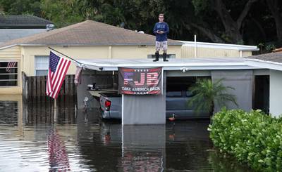 Man on roof after Ft. Lauderdale, FL, record rains, 4-14-2023